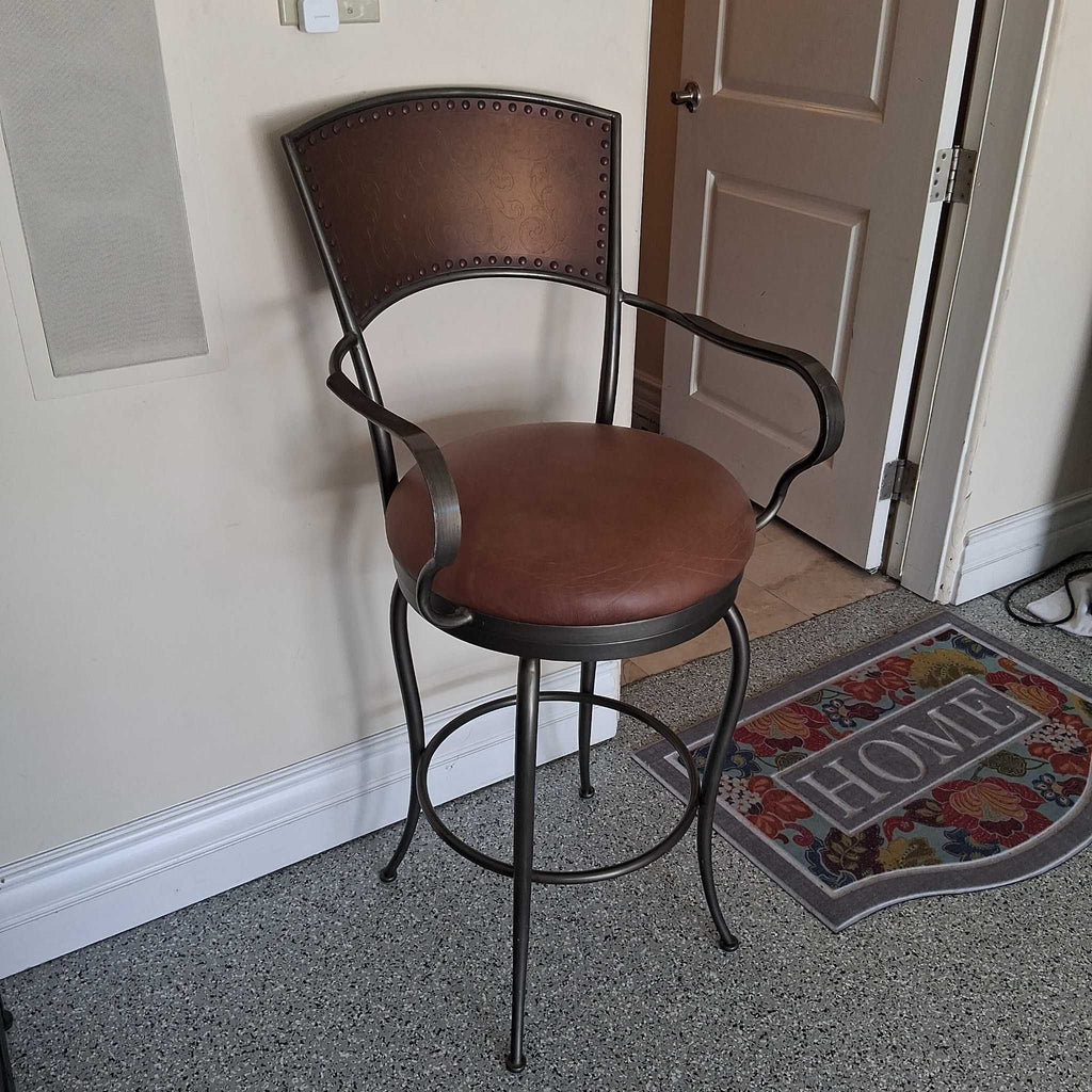 Artistica Home bar stool featuring padded brown leather seat, supportive backrest, and sturdy arms.