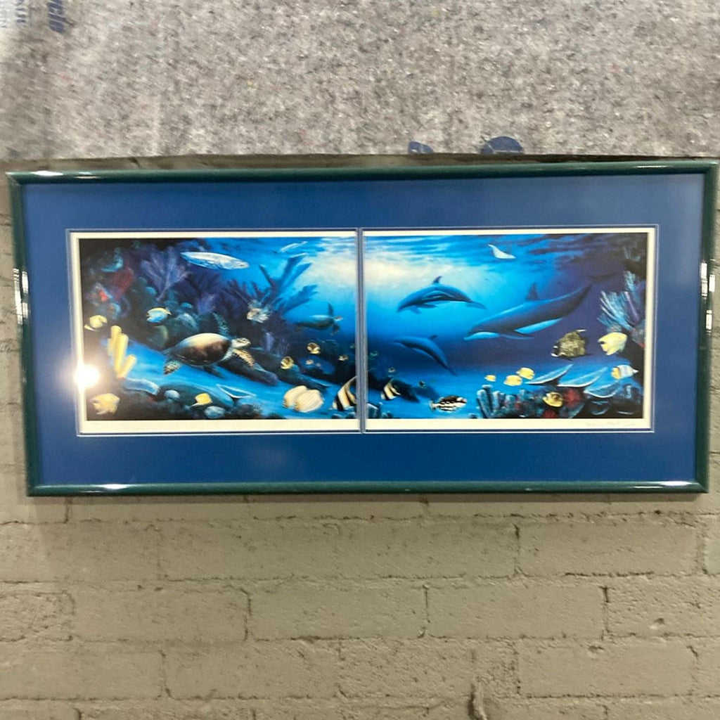 Ocean-themed wall art print with dolphins, sea turtle, and colorful fish, displayed in a deep blue frame, double-matted.  