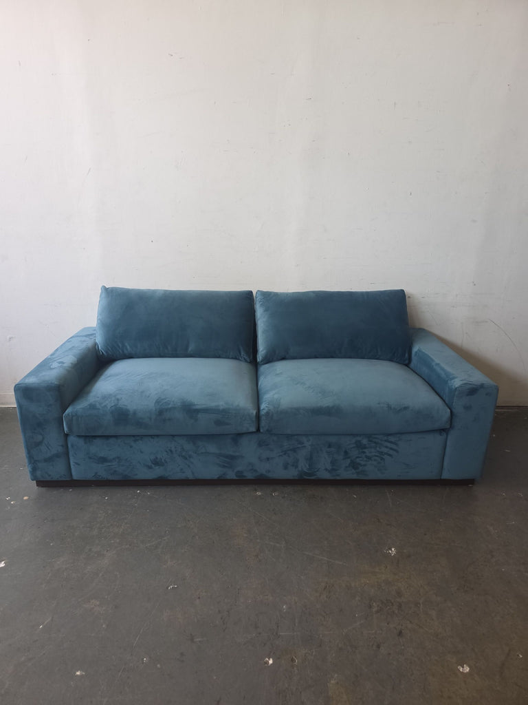 Blue velvet Joybird sleeper loveseat with a boxy modern design, plush cushions, and wide armrests.  