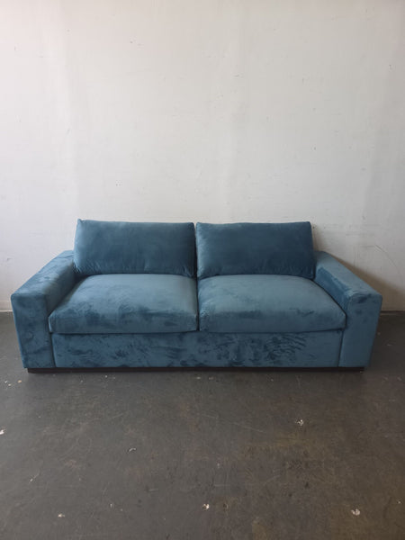 Blue velvet Joybird sleeper loveseat with a boxy modern design, plush cushions, and wide armrests.  