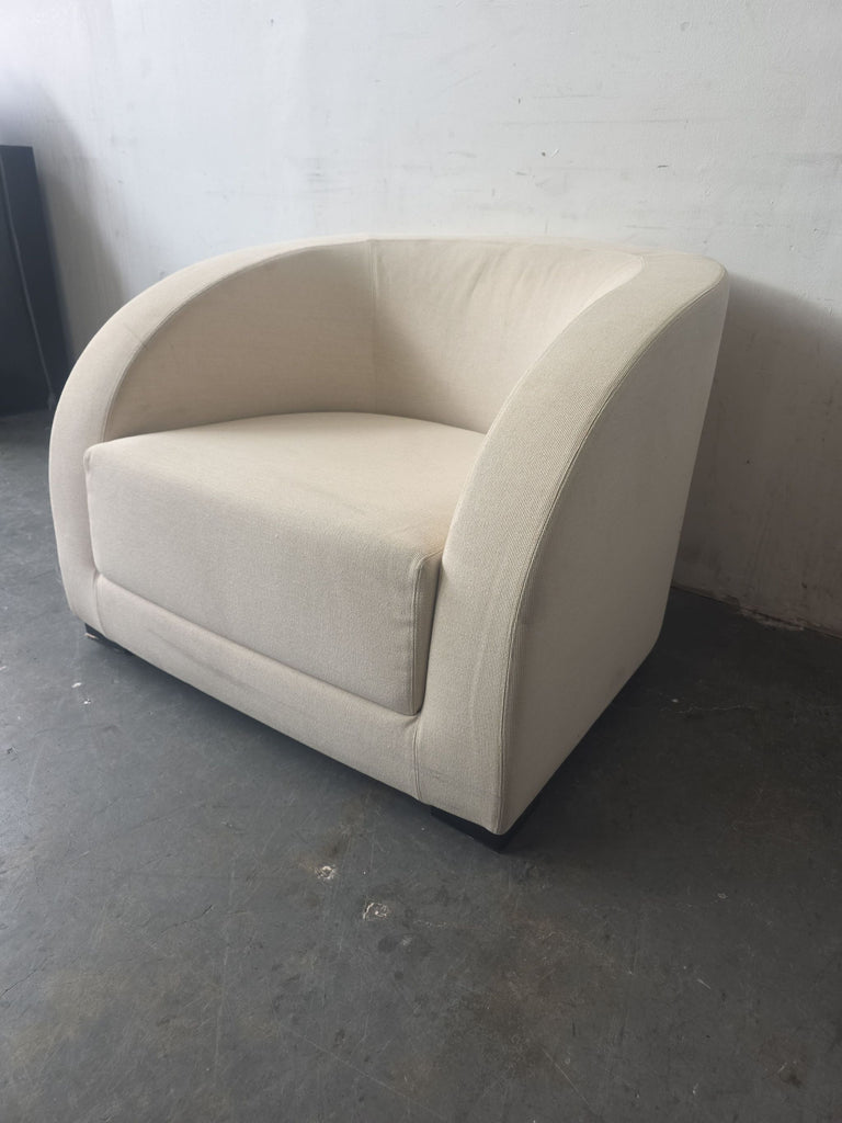Modern lounge chair by Armani Casa in soft beige fabric, featuring a wide, comfortable seat and sleek lines.