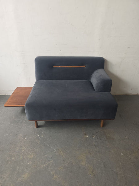 Deep blue sectional sofa with wooden legs, backrest accent, and attached side table for living rooms.