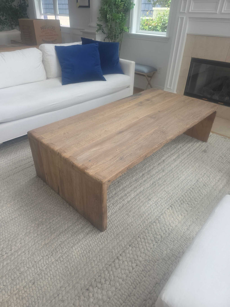 Simple coffee table made from solid wood, featuring a natural finish and generous space for books and decor.