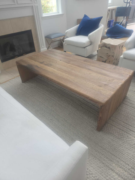Modern rectangular solid wood coffee table with natural finish, offering a spacious surface and sturdy construction.