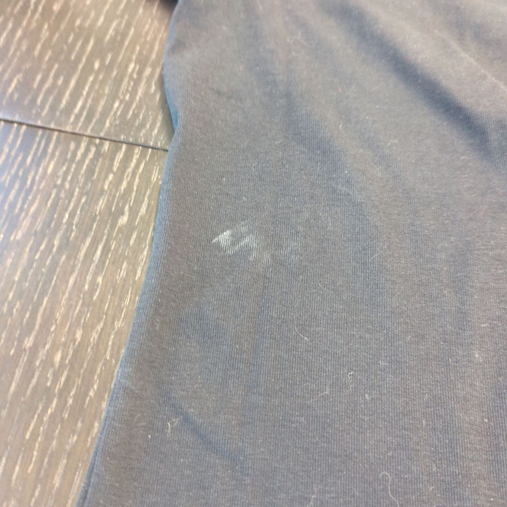 2. Close-up of a faded spot and minor lint on the lower area of a black Uniqlo women's T-shirt.