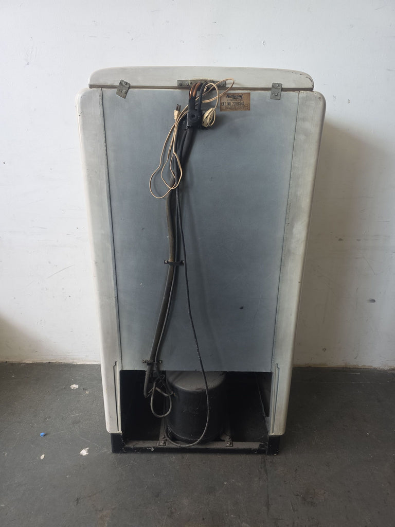 Classic 1930s Hotpoint refrigerator in white, showing signs of age but in working condition for collectors.