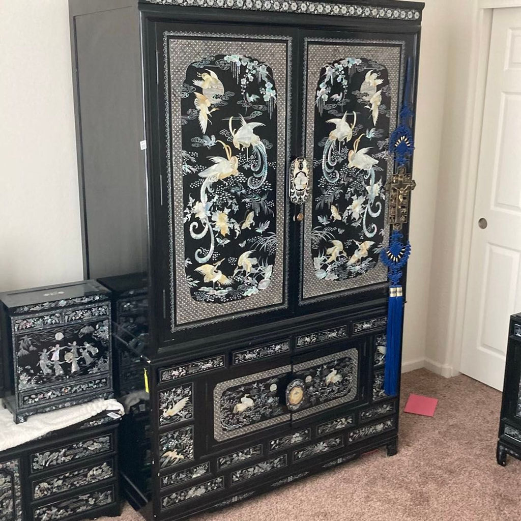 Vintage black cabinet adorned with intricate crane and flower inlays, spacious, excellent condition, from 1976.