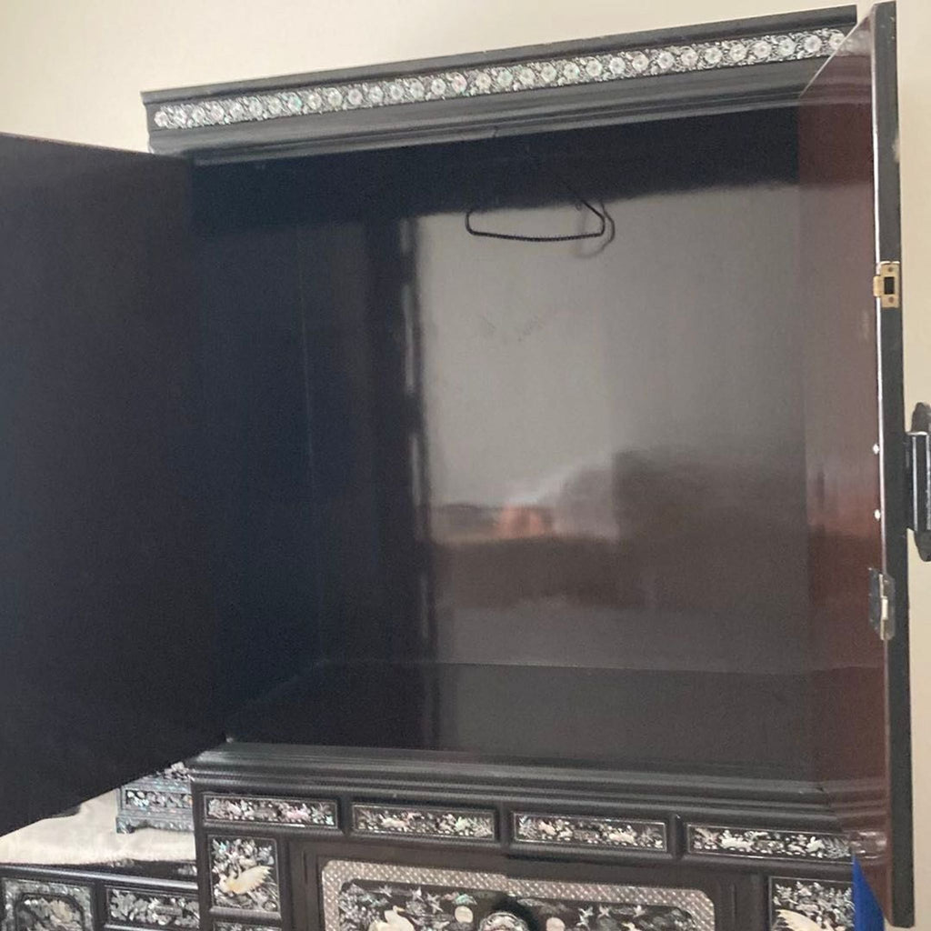 Decorative cabinet with glossy black finish, mother of pearl crane and floral patterns, multiple drawers, gently used.