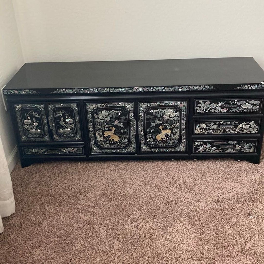 Asian-inspired black lacquer dresser with mother of pearl inlay, offering multiple drawers and a stylish look.