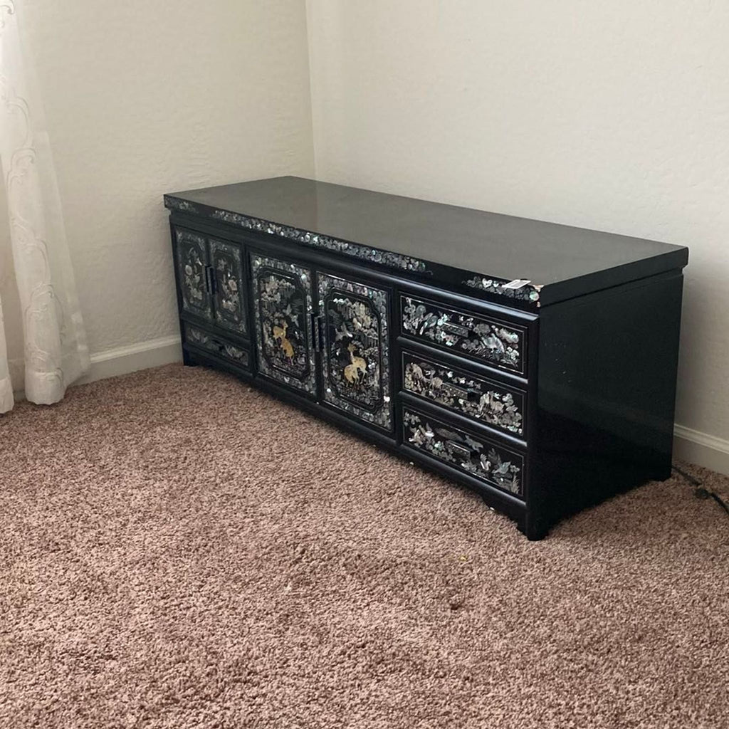 Elegant black dresser featuring mother of pearl designs and spacious storage drawers, ideal for sophisticated spaces.
