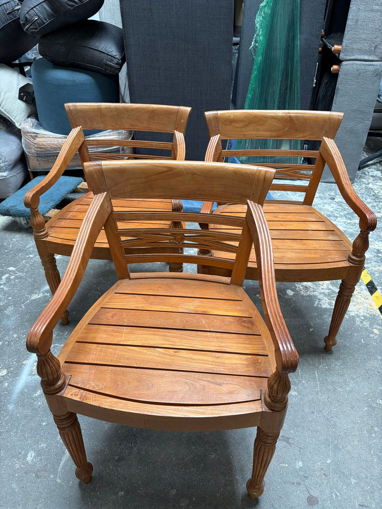 Dining chairs featuring armrests and supportive backs; one chair is pictured with a missing wooden panel.  