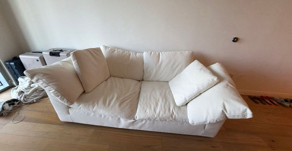 1. White 3-seat Restoration Hardware sofa with plush cushions and wide arms, placed in a living room setting.
