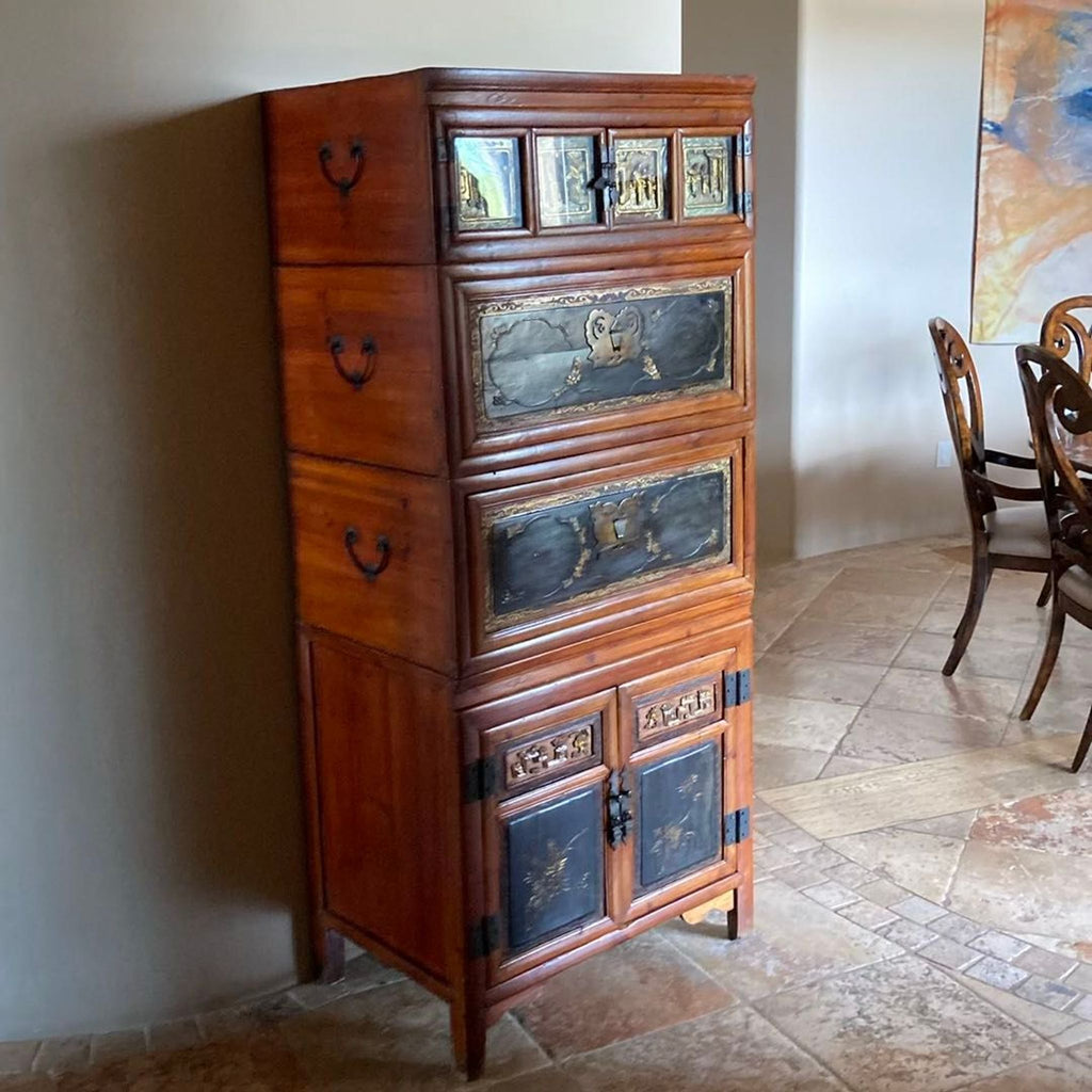 1. Tall wooden dresser with ornate black and gold panels, multiple drawers, and cabinets in a dining room corner.