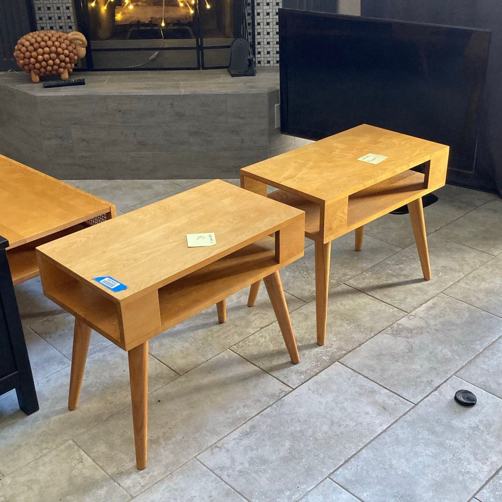 Set of two light wood Conant Ball end tables featuring clean lines, tapered legs, and practical open shelves.