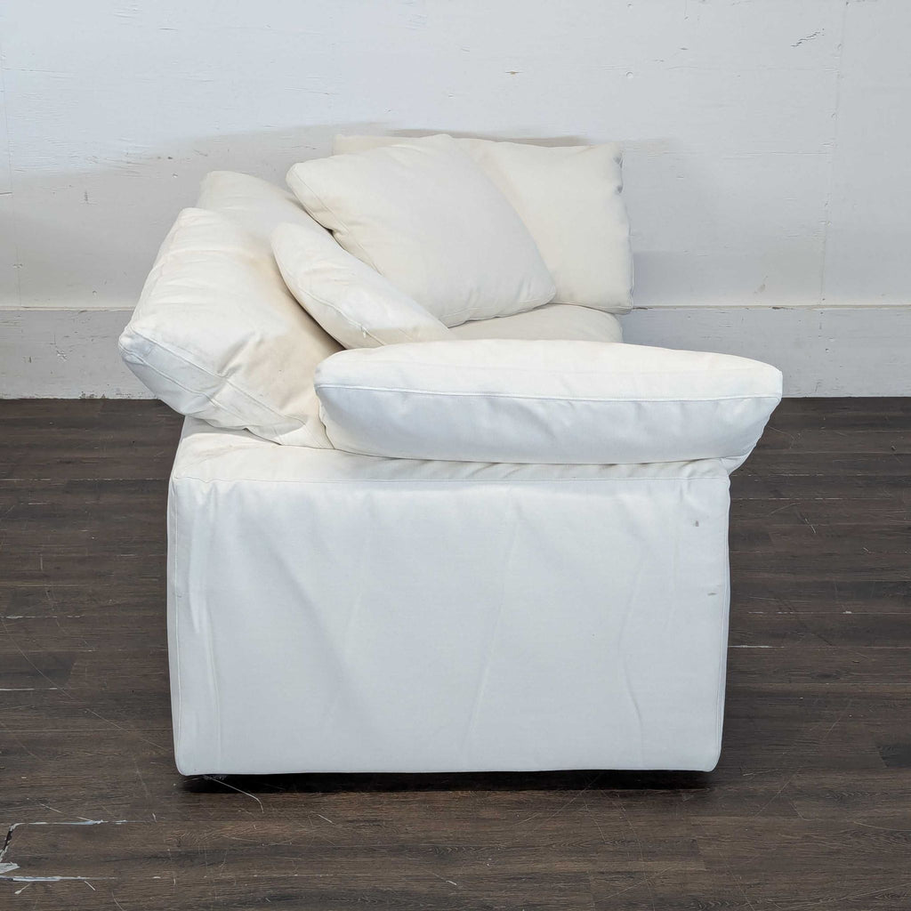 Three-seat Restoration Hardware couch in clean white, offering plush comfort and a contemporary look for living rooms.