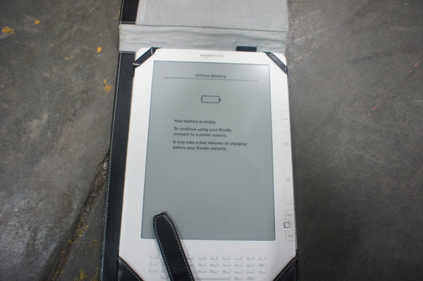 1. Amazon Kindle e-reader in a black case, screen displays low battery warning, on a gray surface.