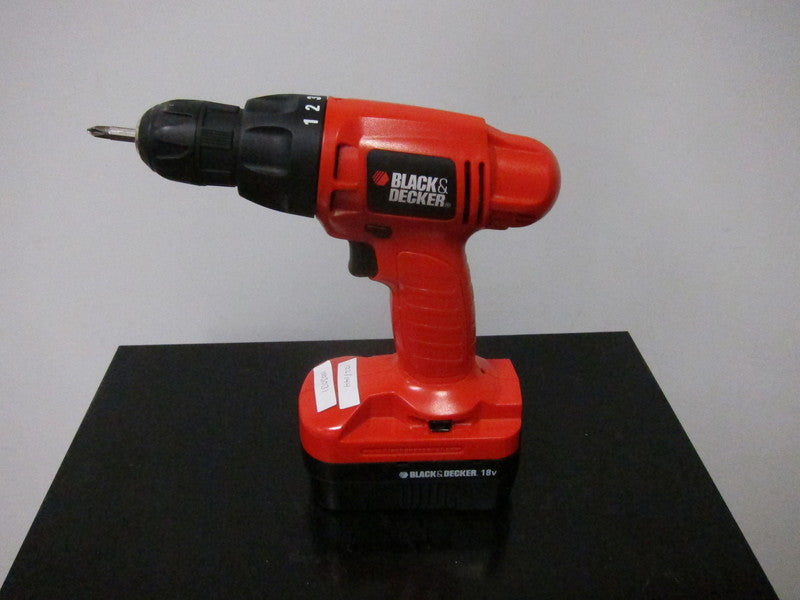 1. Black & Decker PS1800 18V cordless drill in red, shown standing on a black surface.
