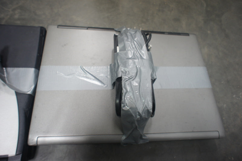 1. Reperch laptop from Computers category with charger taped on top, placed on a cement floor.