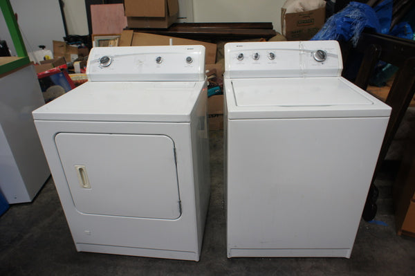 1. Kenmore washer and dryer side by side in a garage setting, with the washer having a top panel, and the dryer having a front panel.