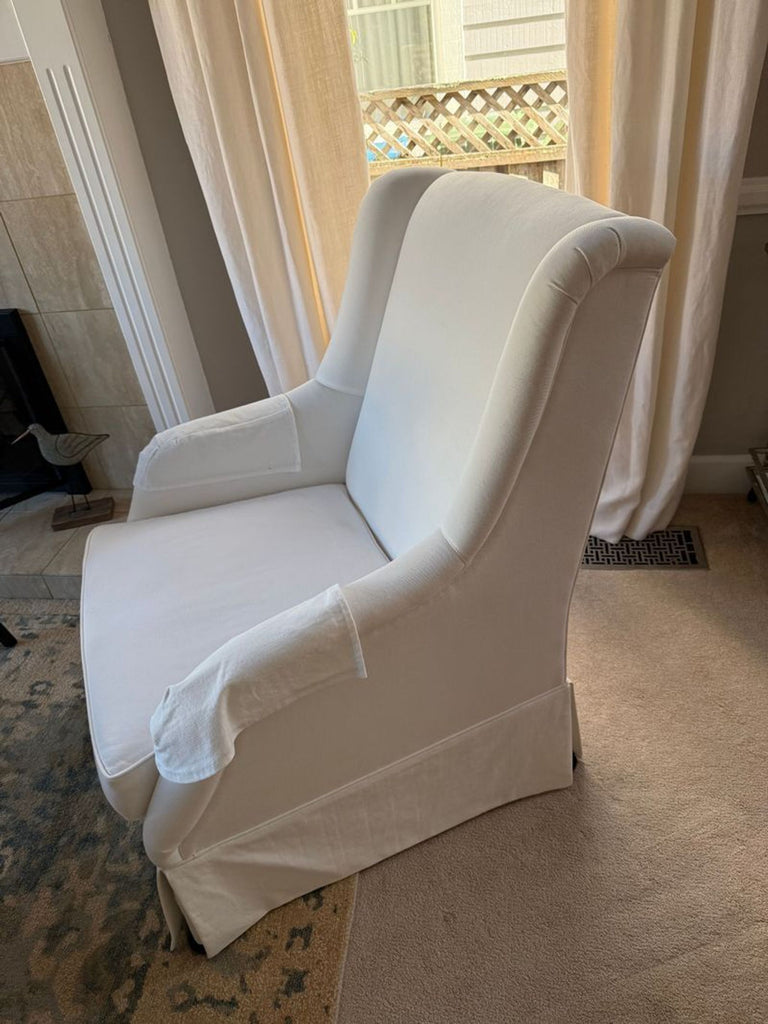 1. Reperch lounge chair in soft white fabric with classic wingback design, placed in a cozy, sunlit living room.  