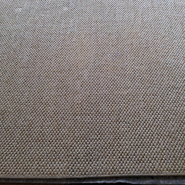 1. Close-up of a woven beige rug with a textured pattern, showing detailed fiber construction.