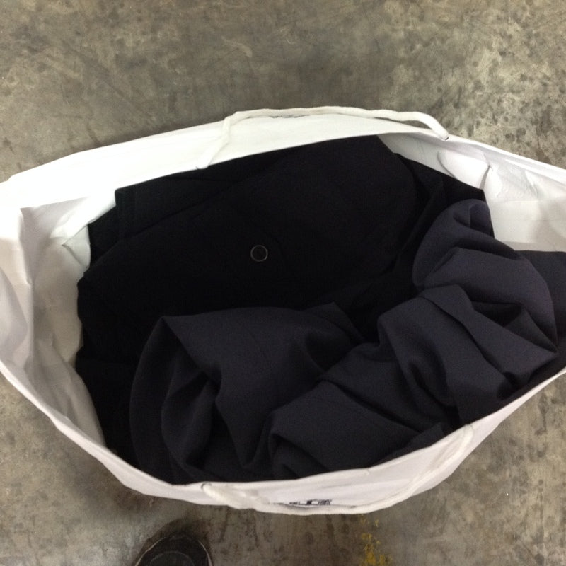 3. Close-up view inside a white bag filled with dark-colored women's Reperch jackets and pants.