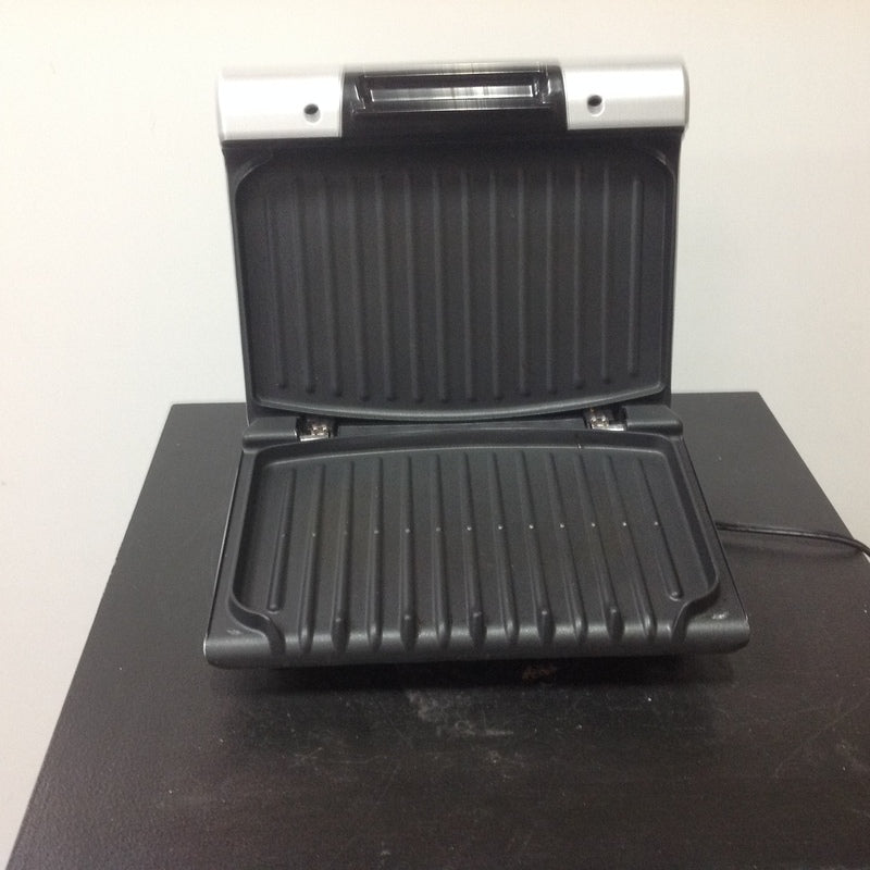 Open George Foreman Grilling Machine with non-stick grill plates visible, ready for grilling food.