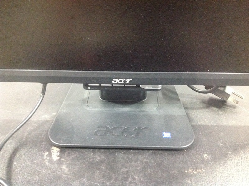 Close-up of the Acer monitor stand showing the Acer brand logo and attached cables.  