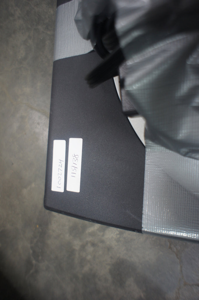 2. Close-up of black Reperch laptop corner with two white inventory labels and duct tape.