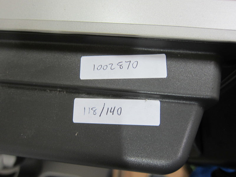 2. Close-up of handwritten inventory labels attached to the base of a Sharp television stand.  