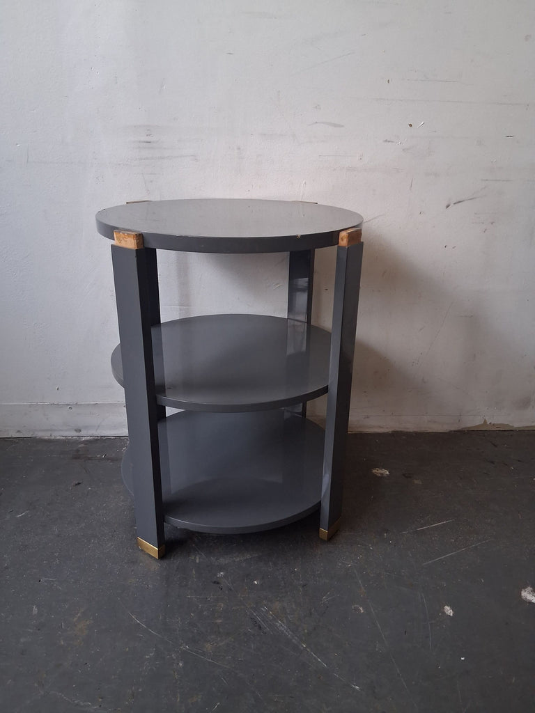 Round gray side table with brass accents, two shelves, modern design by Andrew Martin for Sonder Living.