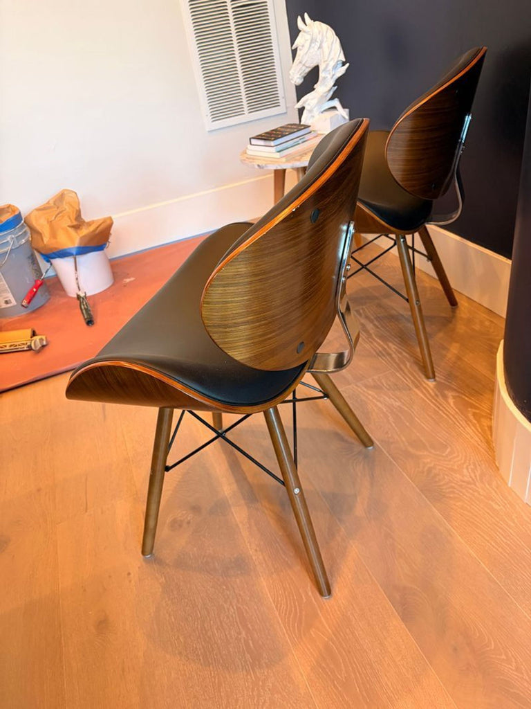 2. Side view of two Armen Living dining chairs, featuring curved wood backs and black upholstery on light wood floors.  