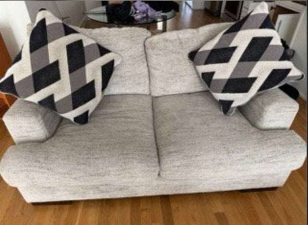 1. Reperch loveseat with light gray upholstery, two geometric-patterned pillows, shown on a wooden floor.