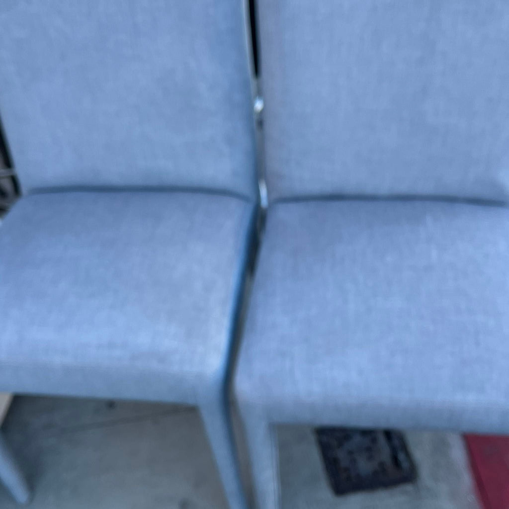 1. Two light blue upholstered dining chairs from New Pacific Direct with simple, modern design.