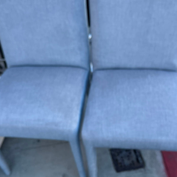 1. Two light blue upholstered dining chairs from New Pacific Direct with simple, modern design.