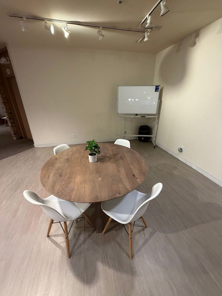 1. Round wooden dining table with four white chairs, placed in a modern room under ceiling spotlights.