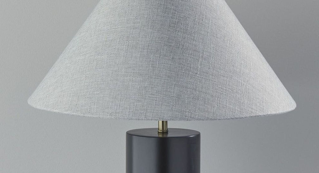 a table lamp with a black base and a white linen shade.