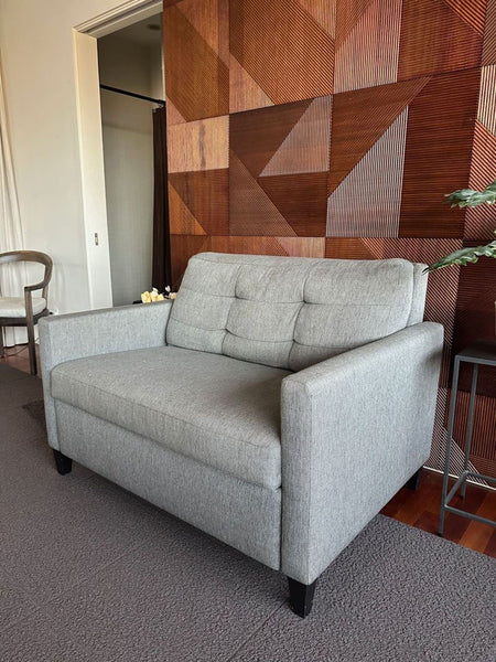 1. Gray Crate & Barrel sleeper sofa with square arms and button-tufted back, set in a modern living space.