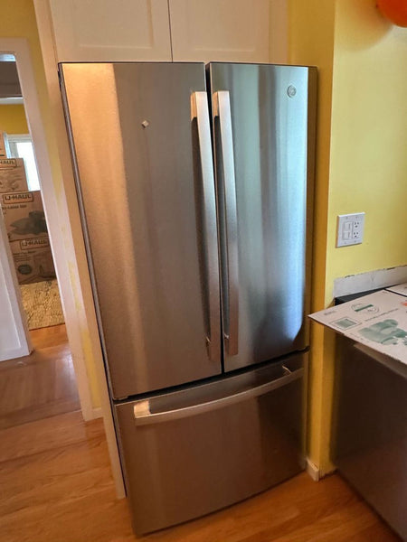 New GE refrigerator for sale, displayed with doors closed in a kitchen setting.