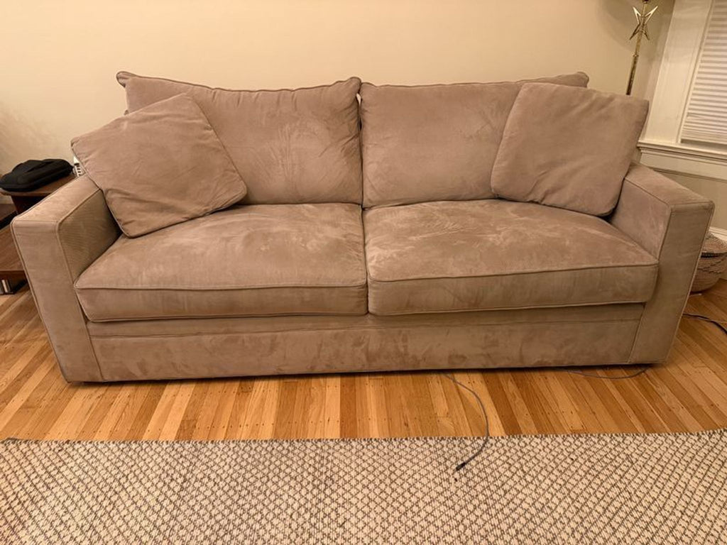 2. Front-facing view of a Room & Board sleeper sofa, upholstered in beige fabric with three large back cushions.
