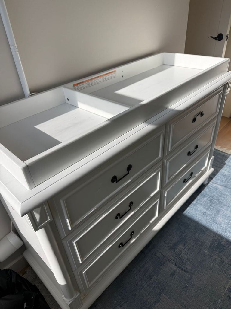 2. Angled view of a white Simmons Juvenile Furniture dresser with six drawers and built-in changing tray on top.  