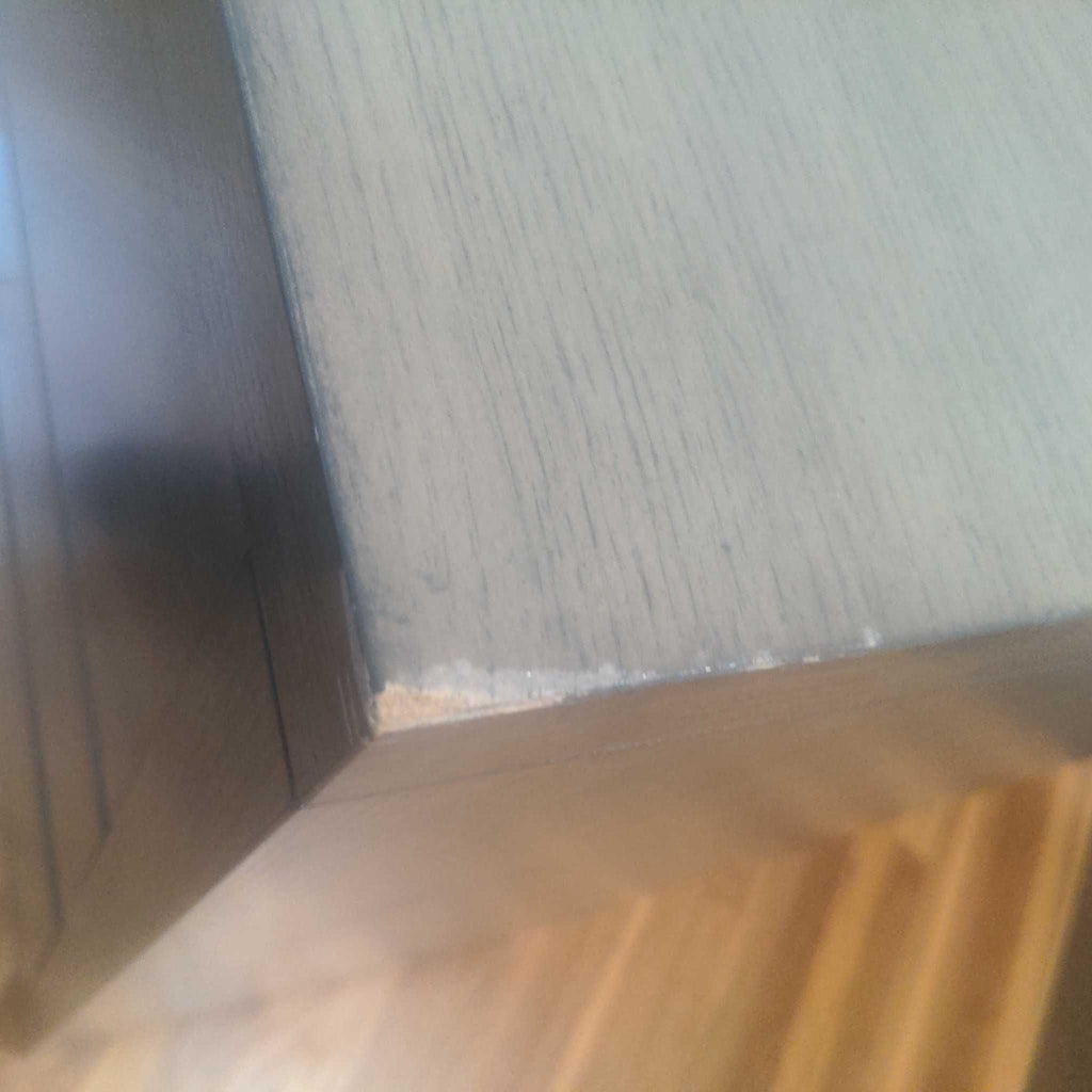 3. Close-up of chipped top corner on a Williams Sonoma Home dresser, revealing minor surface damage to the finish.