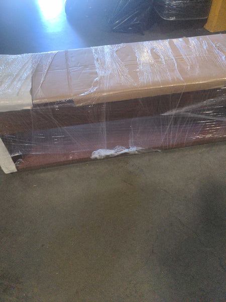 1. Crate & Barrel side or console table wrapped in plastic and cardboard, shown on a warehouse floor.