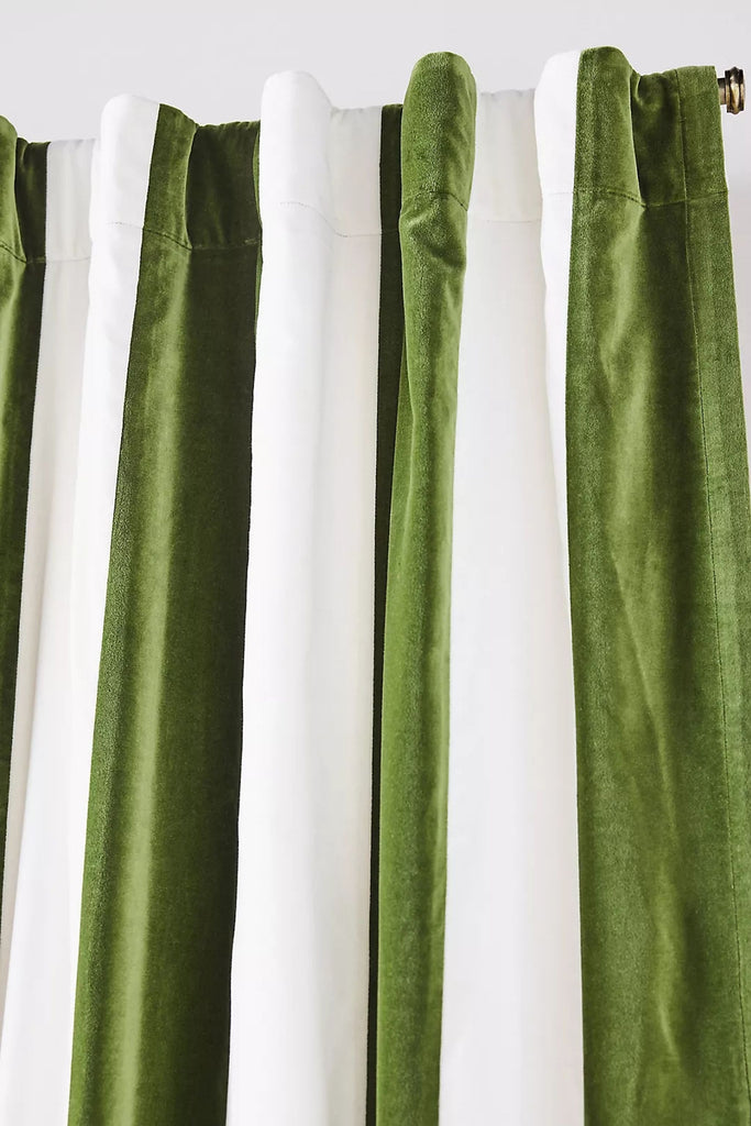 3. Trova Velvet Pieced Striped Curtain by Anthropologie, featuring lush green and white stripes, draped on a rod.