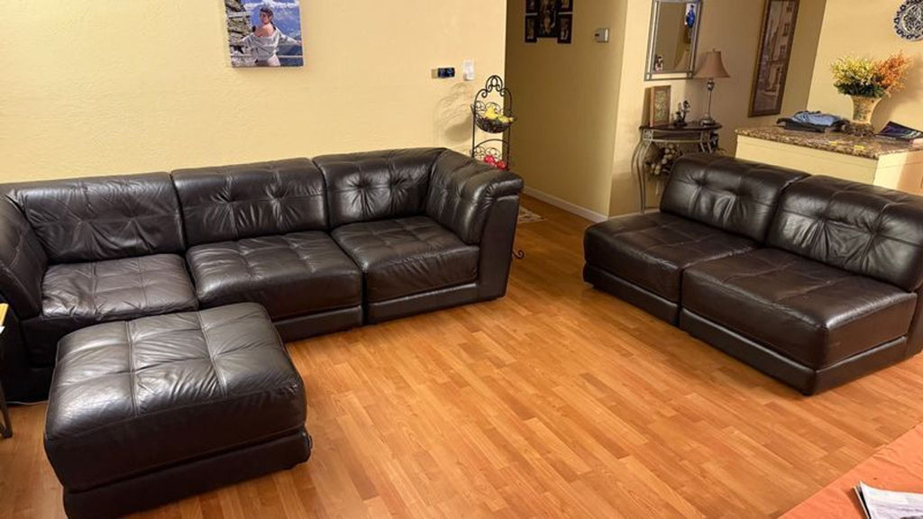 2. Chateau d’Ax sectional set: modular brown leather sofas separated, featuring tufted cushions, in a cozy living room.