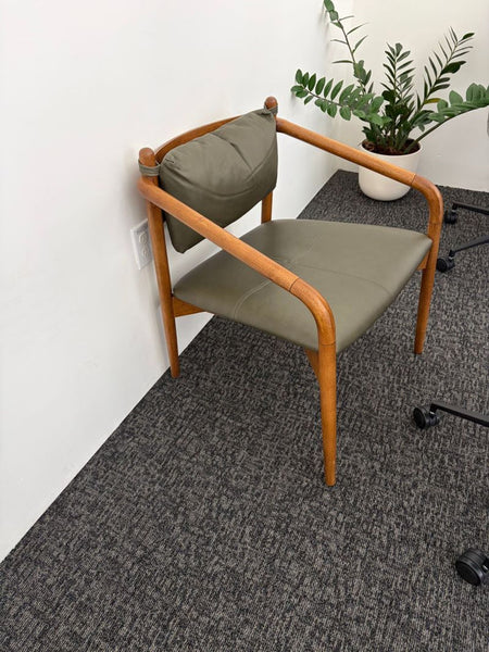 1. Olive green Article dining chair with wooden frame and cushion, set in an office with a plant nearby.