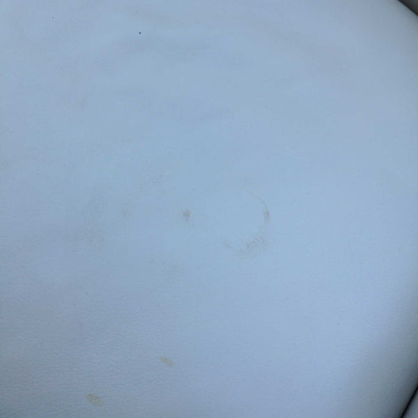 - Close-up of a white Reperch loveseat cushion showing minor surface stains and wear.