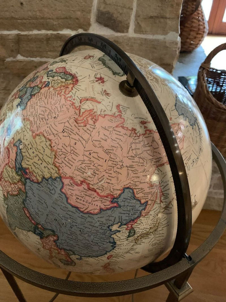 Close-up of a detailed world globe on a metal axis.