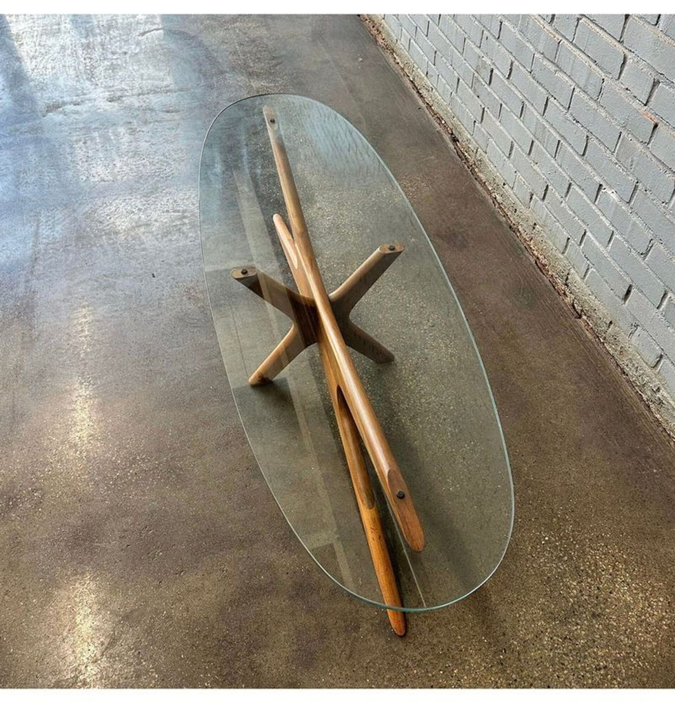 Angled overhead shot of a coffee table by Adrian Pearsall, with a star-shaped wood base and clear glass top.