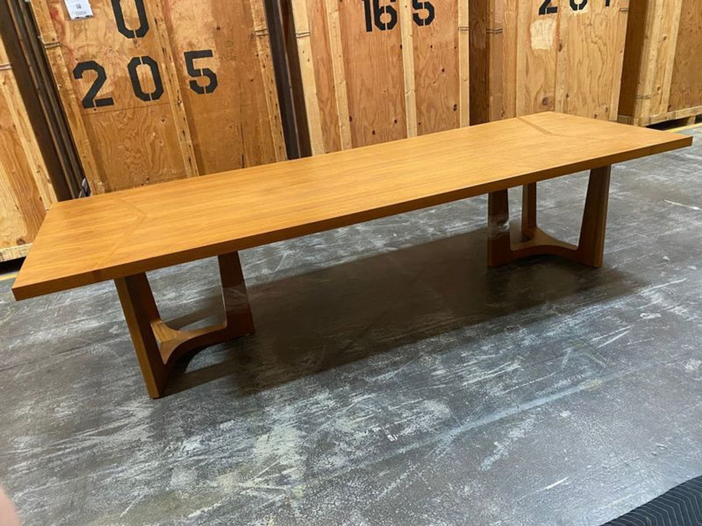 Modern round coffee table with a minimalist design, labeled as Trice Dining Table by Holly Hunt, 2015.
